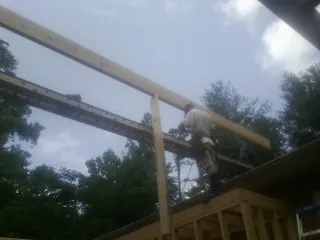 Carpenter setting a ridge beam over a new addition frame — Ice Dam Removal by Roofing Brothers in Mesa